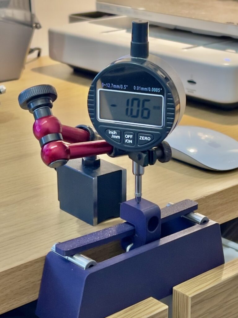 Three-point bending test stand with a digital dial indicator measuring center deflection of a printed specimen